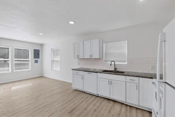 a kitchen with granite countertop a sink and cabinets