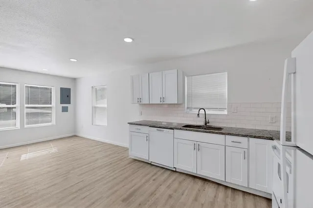 a kitchen with granite countertop a sink and cabinets