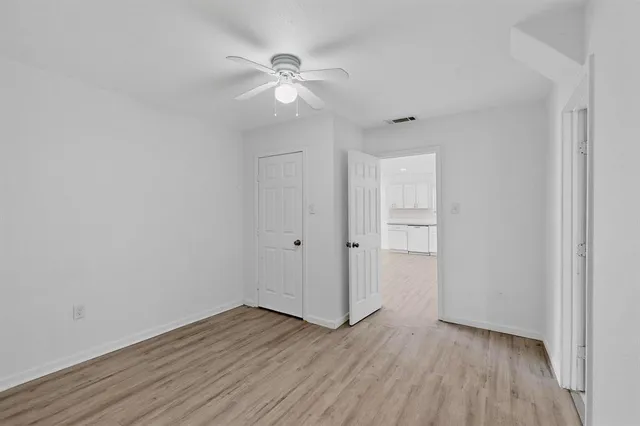 a view of an empty room with wooden floor