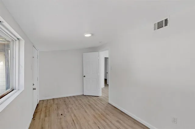a view of a room with wooden floor and brick walls