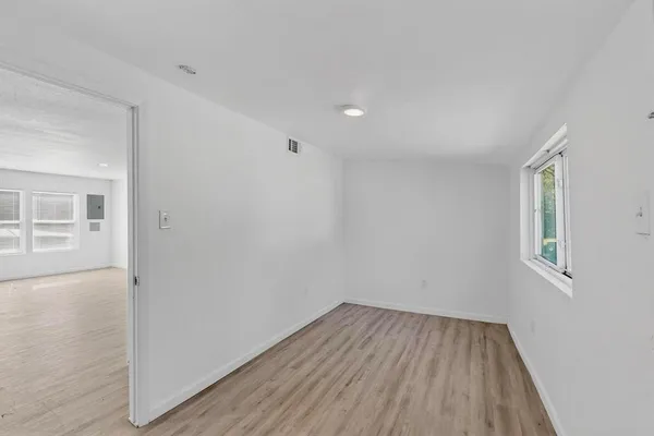 wooden floor in an empty room with a window