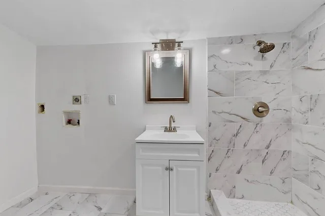 a bathroom with a sink a mirror and shower