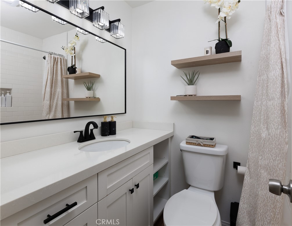 12200 Montecito Road, Unit D104 Seal Beach, CA 90740 - Photo 14 of 25 a bathroom with a toilet a sink and mirror