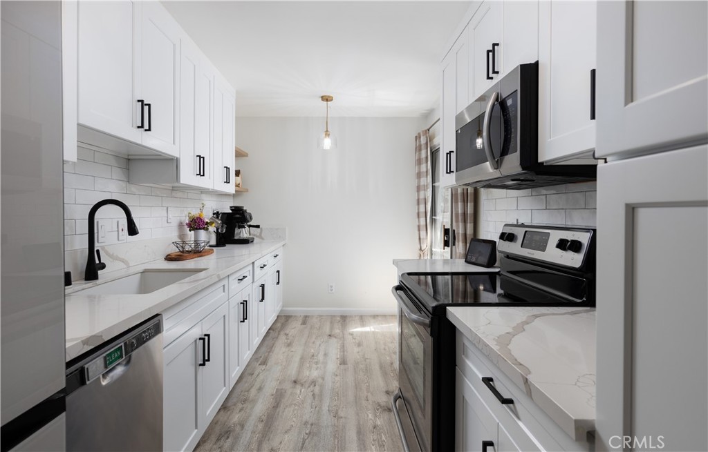 12200 Montecito Road, Unit D104 Seal Beach, CA 90740 - Photo 6 of 25 a kitchen with kitchen island stainless steel appliances a sink a stove and cabinets