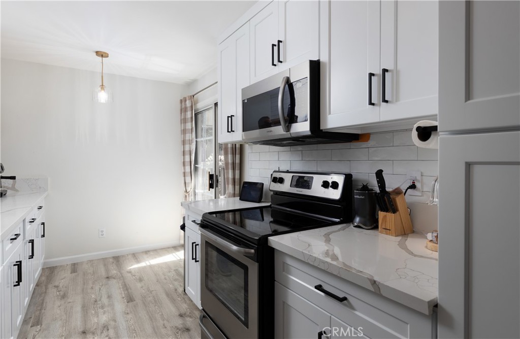 12200 Montecito Road, Unit D104 Seal Beach, CA 90740 - Photo 7 of 25 a kitchen with stainless steel appliances granite countertop a stove and a microwave