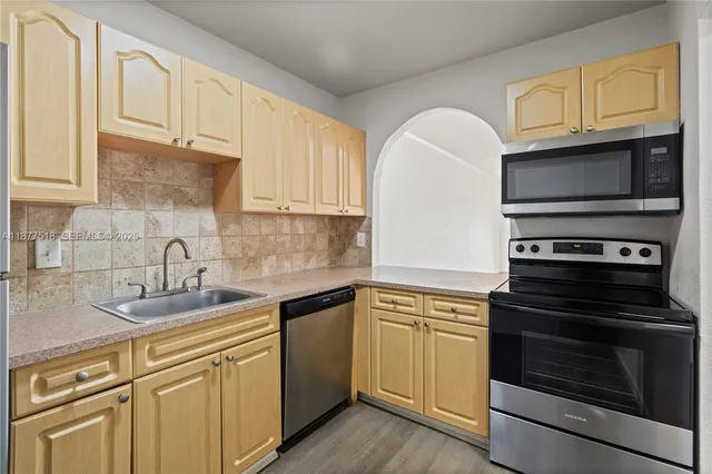 a kitchen with granite countertop cabinets stainless steel appliances and a sink