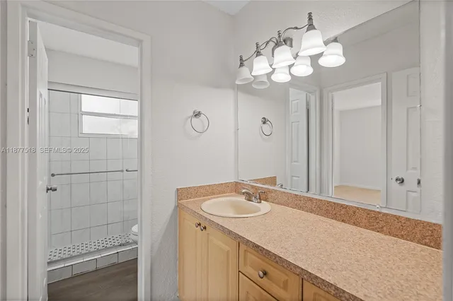 a bathroom with a sink a light fixture and a mirror