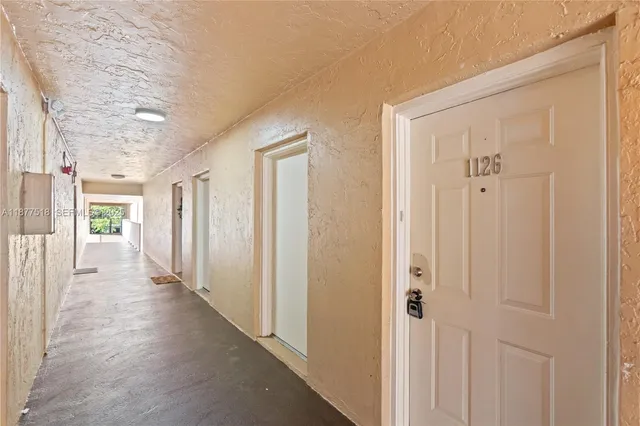 a view of a hallway with wooden floor and closet area