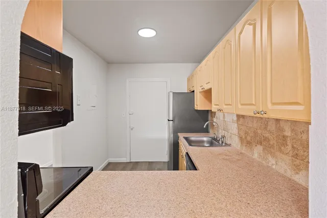 a kitchen with stainless steel appliances kitchen island sink refrigerator and microwave