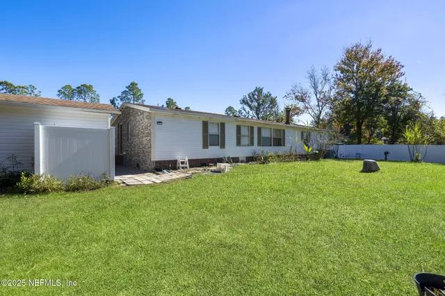 a view of a house with backyard and sitting area