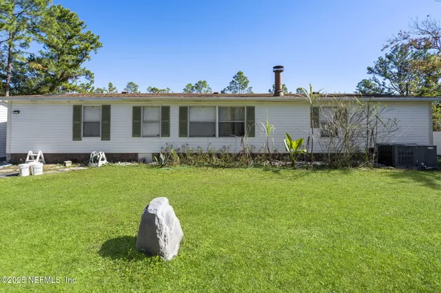 a front view of a house with a garden and plants