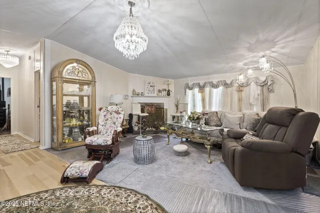 a living room with furniture chandelier and a large window