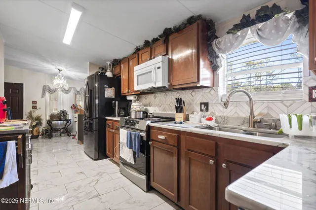 a kitchen with stainless steel appliances granite countertop a sink stove and cabinets