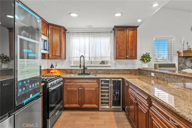 a kitchen with stainless steel appliances granite countertop a stove a sink a refrigerator and a refrigerator