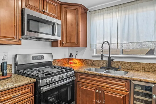 a view with granite countertop kitchen island a sink appliances and a counter space