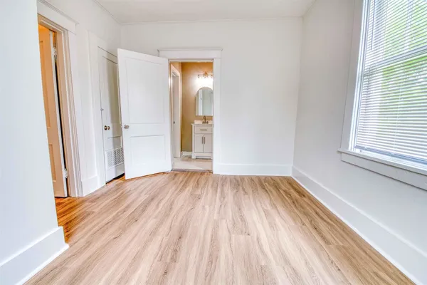 a view of a room with wooden floor and window