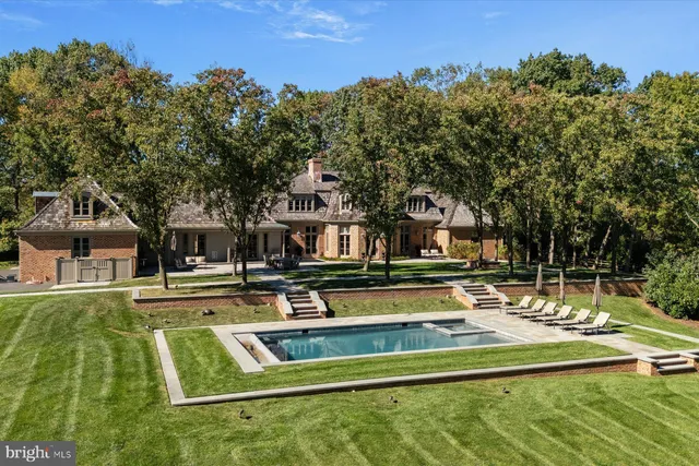 a view of an house with swimming pool and trees in the background