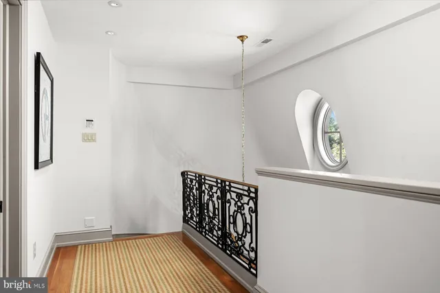 a bedroom with a bed a large window and potted plant on the dresser