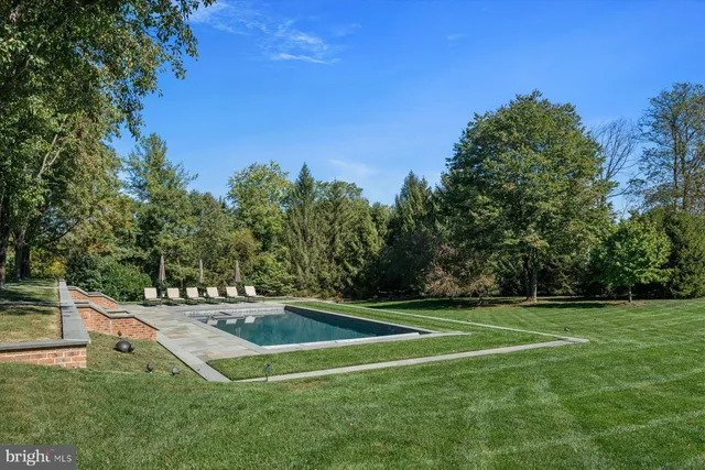 an aerial view of residential house with outdoor space and trees all around