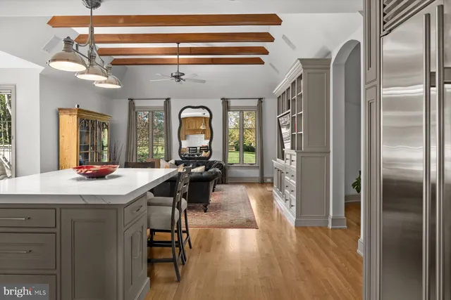 a room with stainless steel appliances kitchen island granite countertop furniture and a wooden floor