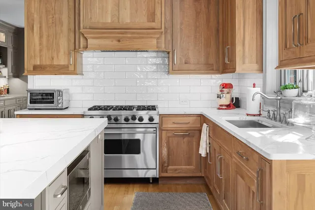 a kitchen with granite countertop a sink stove and cabinets