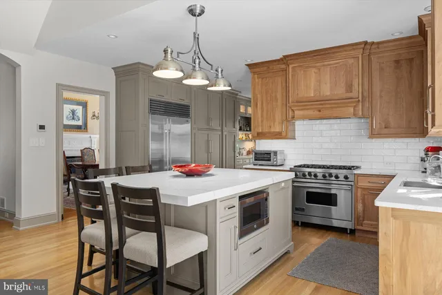 a kitchen that has a stove a table and chairs in it