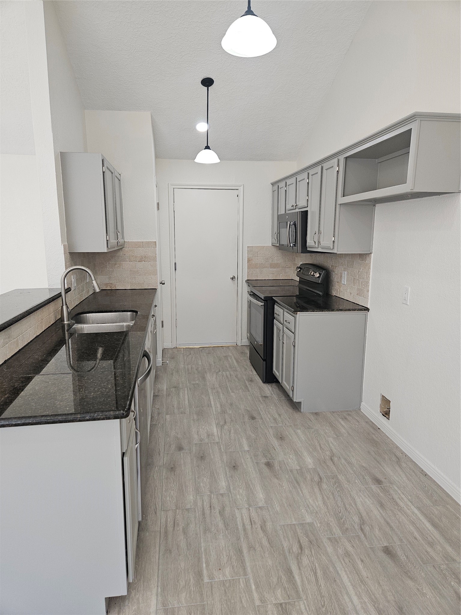 4426 Waterfall Way Sugar Land, TX 77479 - Photo 6 of 11 a kitchen with granite countertop a sink stainless steel appliances and cabinets