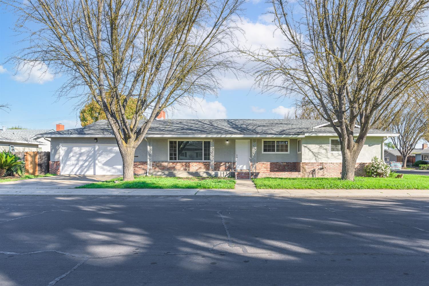 a front view of a house with a yard and trees
