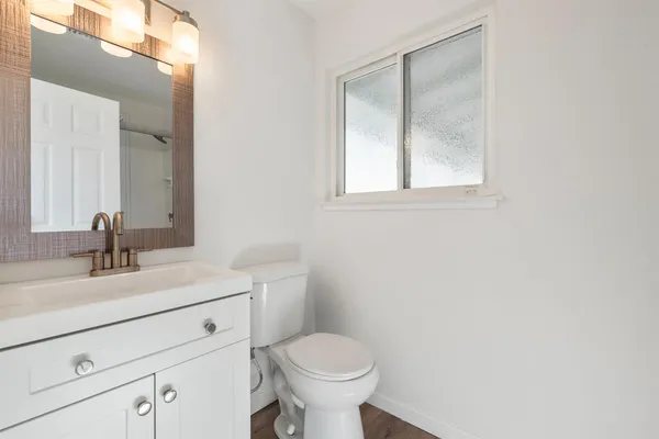 a bathroom with a toilet sink and mirror