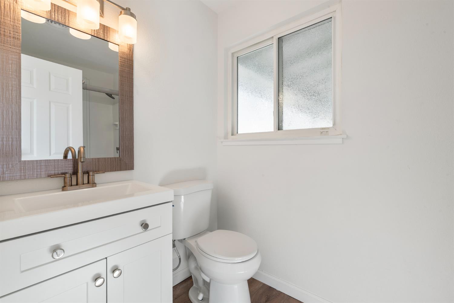 1713 Wolverine Way Modesto, CA 95355 - Photo 15 of 28 a bathroom with a toilet sink and mirror