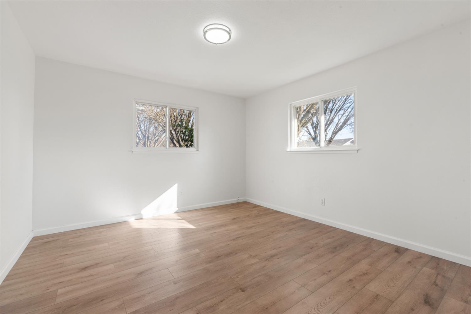 1713 Wolverine Way Modesto, CA 95355 - Photo 16 of 28 an empty room with wooden floor and window