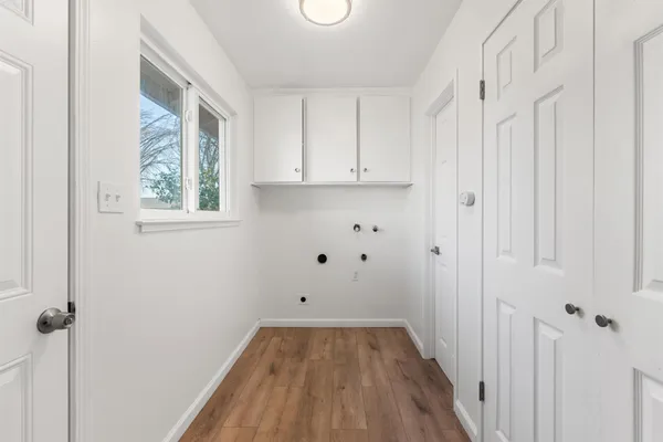 a view of a room with wooden floor and white walls