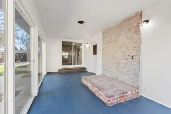 a view of a hallway with wooden floor and a bathroom