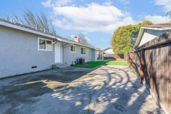 a view of a house with a small yard and wooden fence