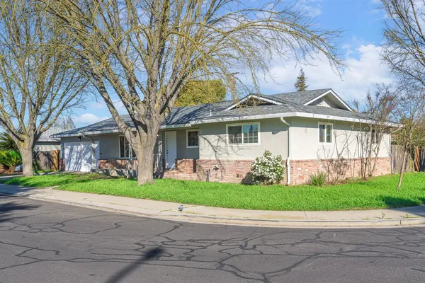 a front view of a house with a garden and plants