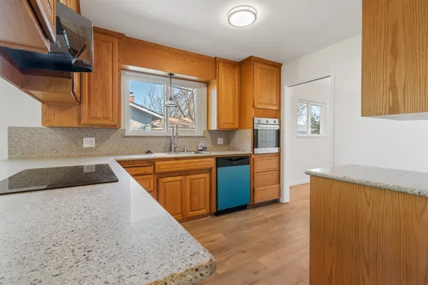 a kitchen with stainless steel appliances granite countertop a sink and a refrigerator