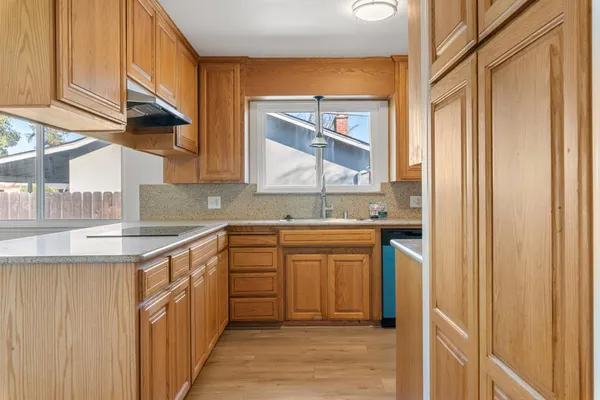 a kitchen with stainless steel appliances granite countertop a sink and a stove with wooden cabinets