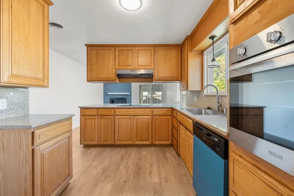 a kitchen with a sink a window and cabinets