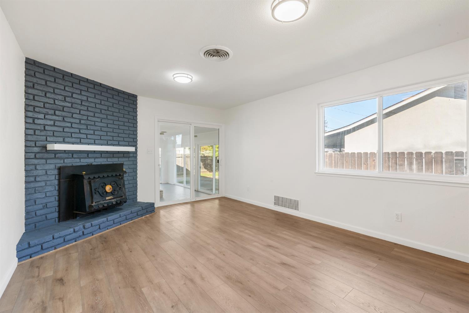 1713 Wolverine Way Modesto, CA 95355 - Photo 9 of 28 a view of an empty room with wooden floor fireplace and a window