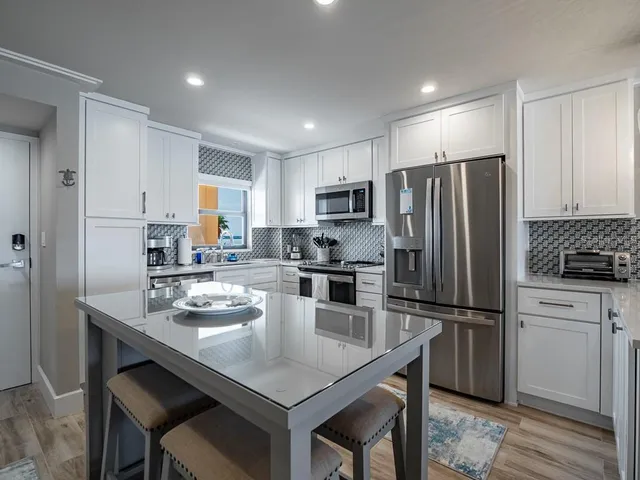 a kitchen with a refrigerator a stove a sink and cabinets