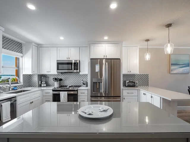 a kitchen with refrigerator and chairs