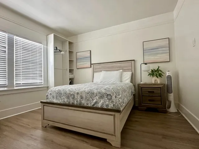 a bedroom with a bed and wooden floor