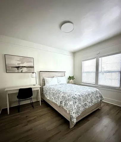 a bedroom with a bed a table and chair