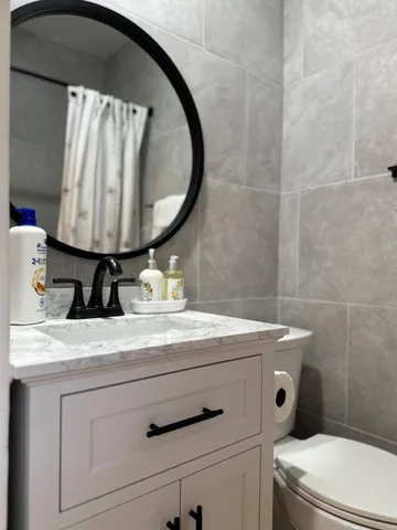 a bathroom with a sink a toilet and a mirror