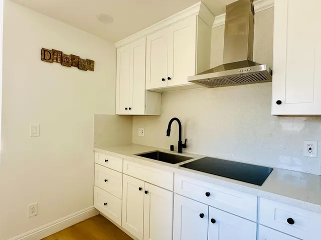 a kitchen with white cabinets and a sink