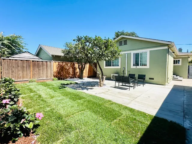 a view of a house with backyard and sitting area