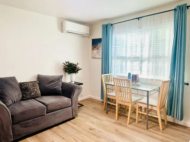 a living room with furniture and wooden floor