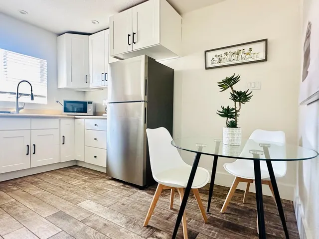 a kitchen with stainless steel appliances granite countertop a refrigerator a stove a sink and white cabinets