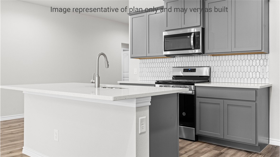 1409 Irigoyen Street Corpus Christi, TX 78415 - Photo 11 of 38 a kitchen with stainless steel appliances granite countertop a sink and a microwave