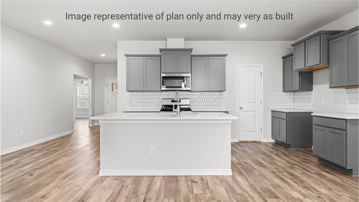 1409 Irigoyen Street Corpus Christi, TX 78415 - Photo 12 of 38 a kitchen with cabinets wooden floor and a sink